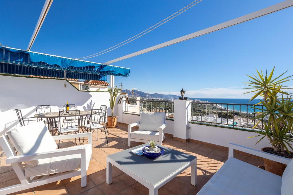 a balcony with a table and chairs and the ocean at Plaza Cadiz 4 overlooking Playazo in Nerja