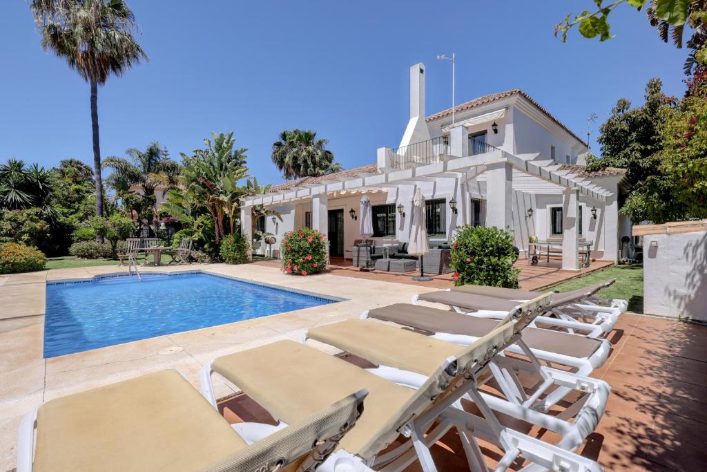 a villa with a swimming pool and lounge chairs at El Cafetal de Veronica in Marbella