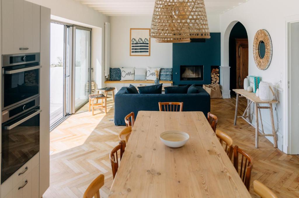 a living room with a table and a blue couch at La Perle in Plobannalec-Lesconil