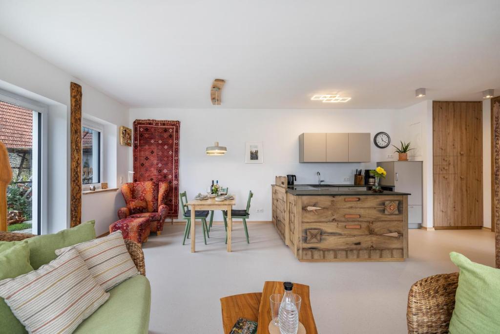 a living room with a kitchen and a table at Alb-Sonne Ferienwohnung in Sonnenbühl