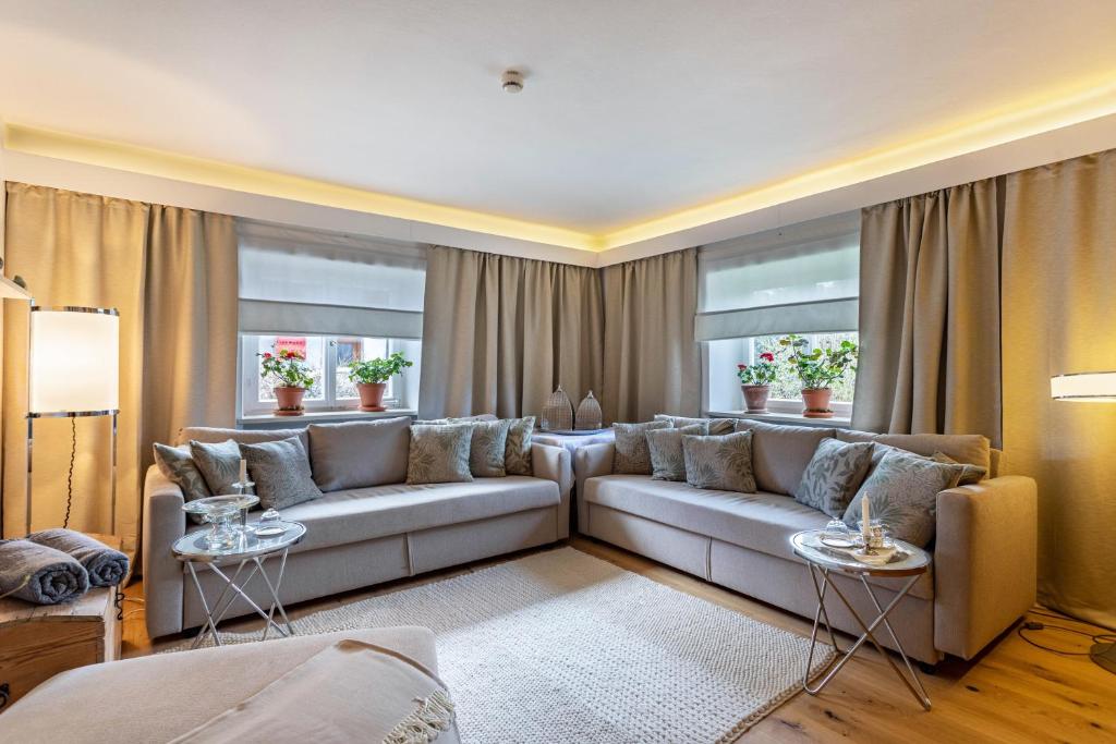 a living room with a couch and two tables at Haus Alpenveilchen - Appartement 2 in Schönau am Königssee