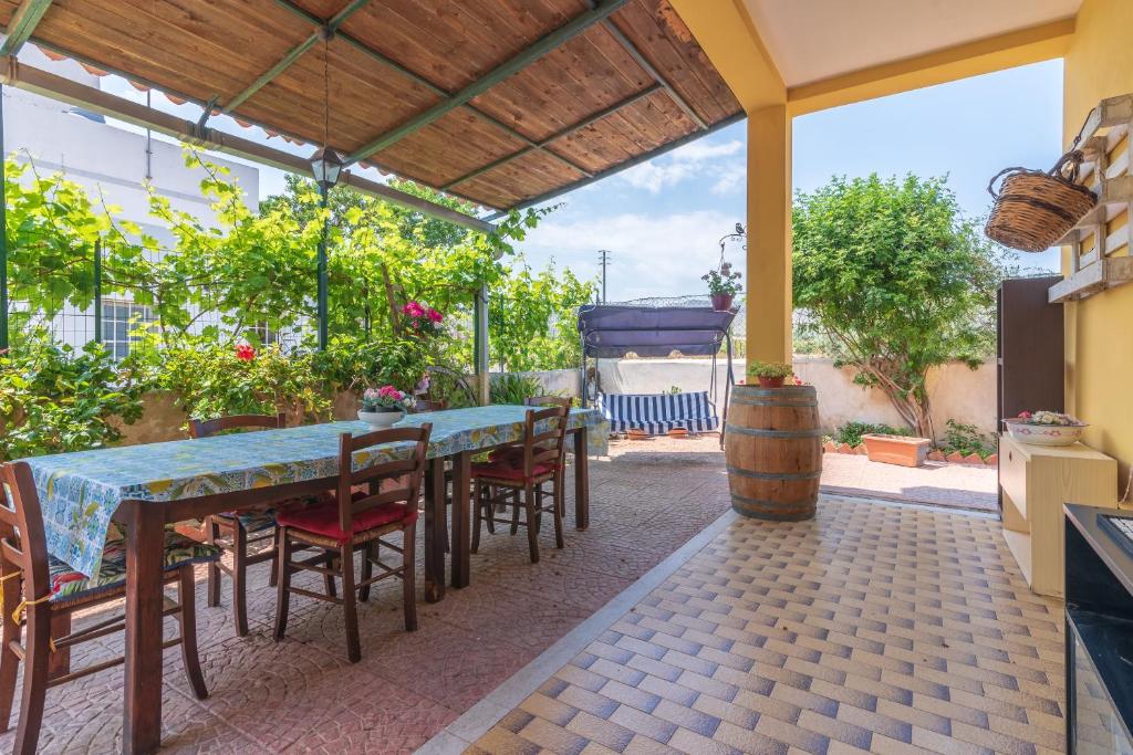 a patio with a table and chairs and a barrel at Casale siculo in Avola