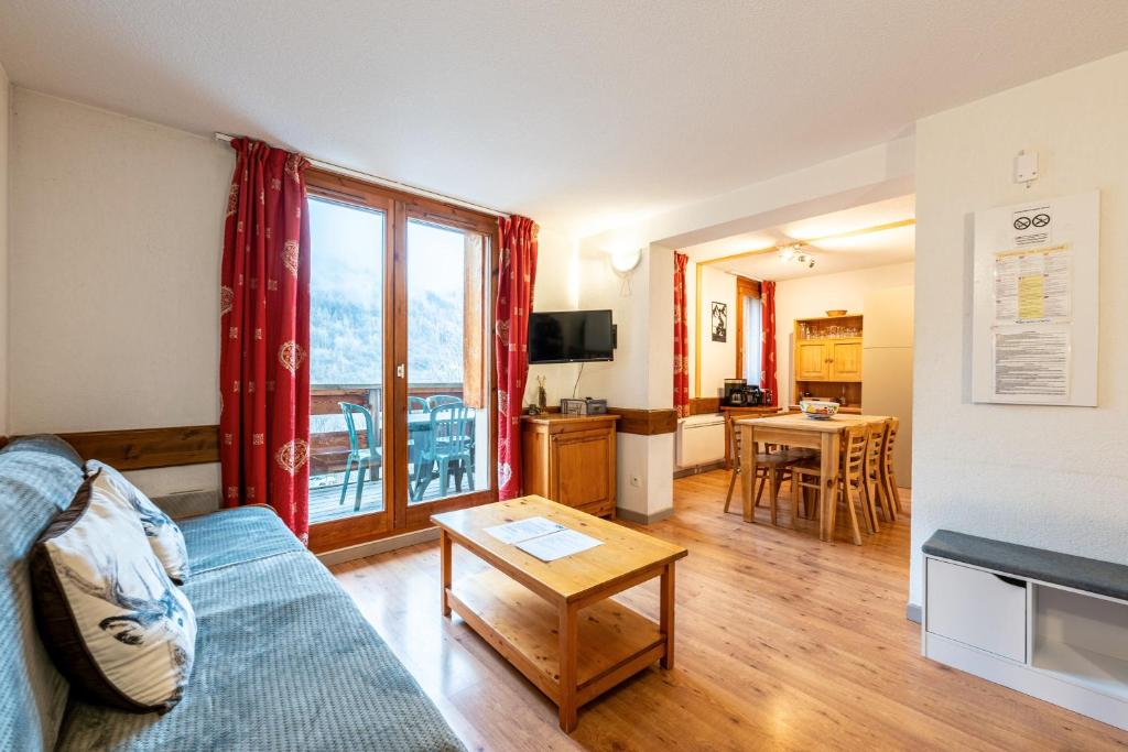 a living room with a couch and a table at Valloire - Appartement avec piscine in Valloire
