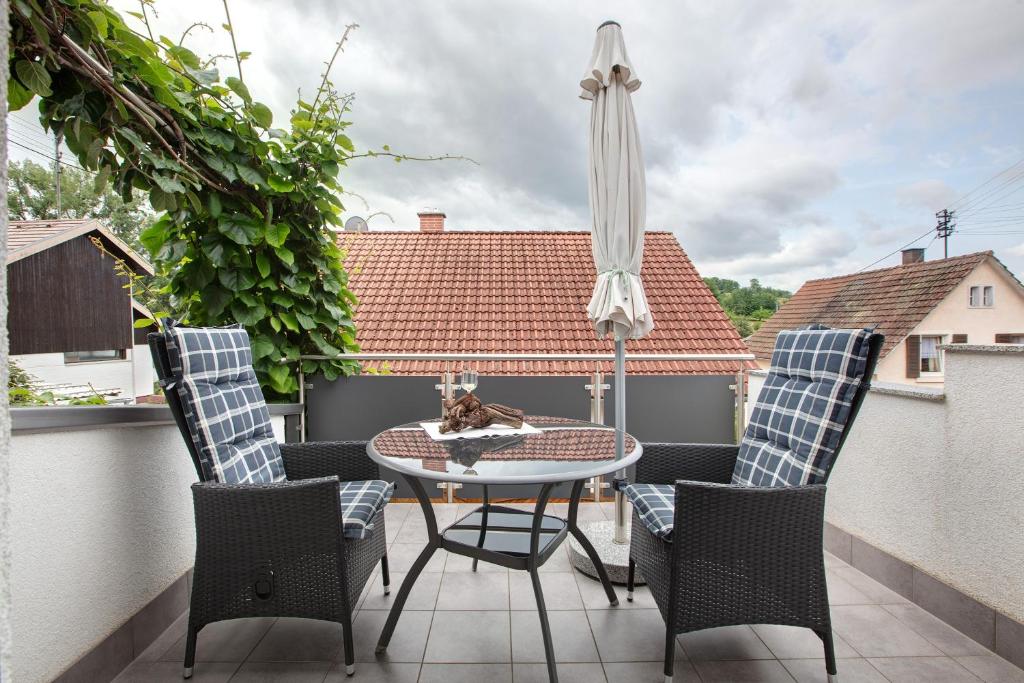 a patio with a table and chairs and an umbrella at Ferienhaus am Blumengässle in Feldberg