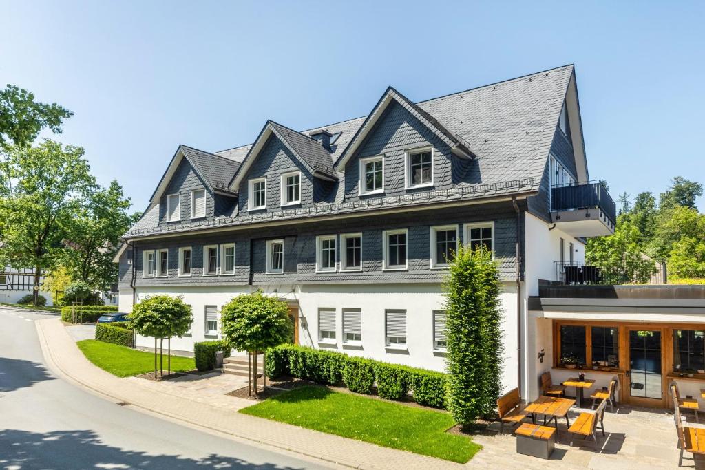 a large white house with a black roof at Doppelzimmer Mit Terrasse in Schmallenberg