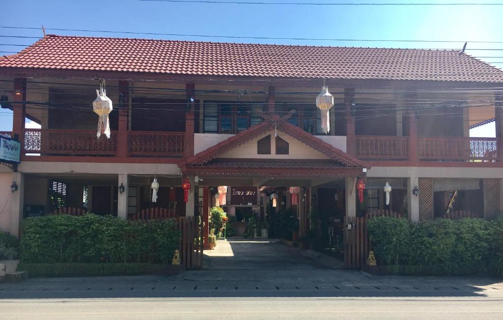 un edificio con techo rojo y pasarela en Chok-wasana Guest House, en Mae Sariang