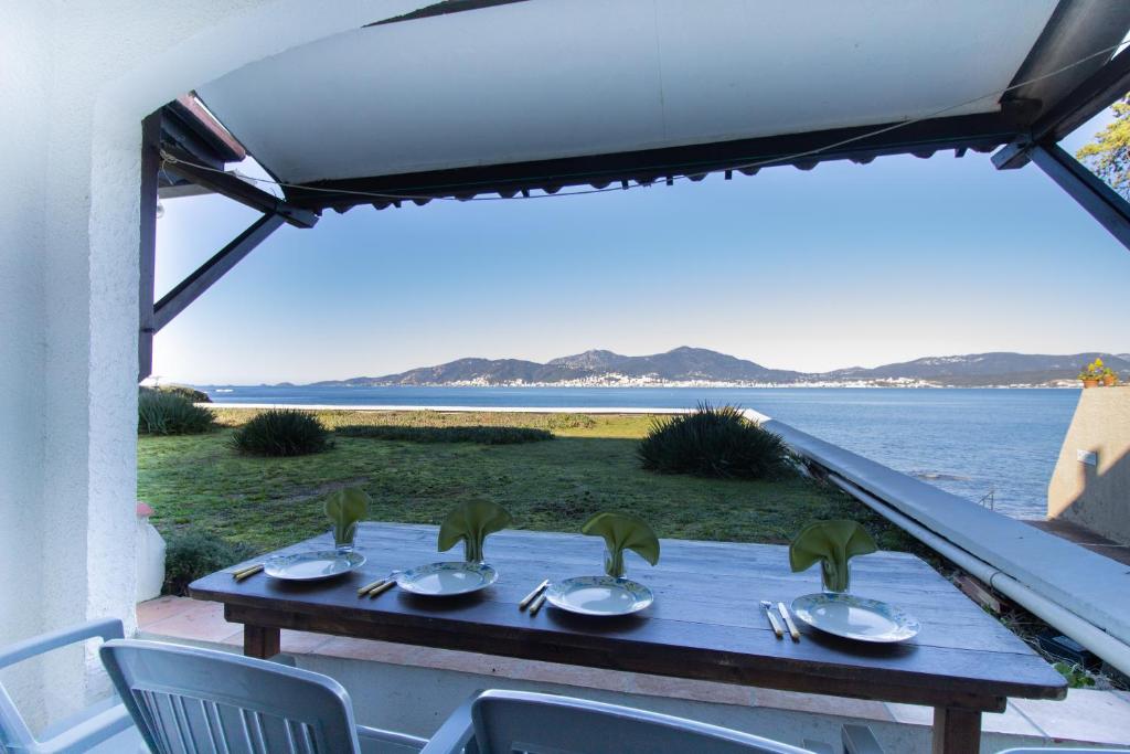 a table with chairs and a view of the water at Studio pieds dans l'eau in Grosseto-Prugna
