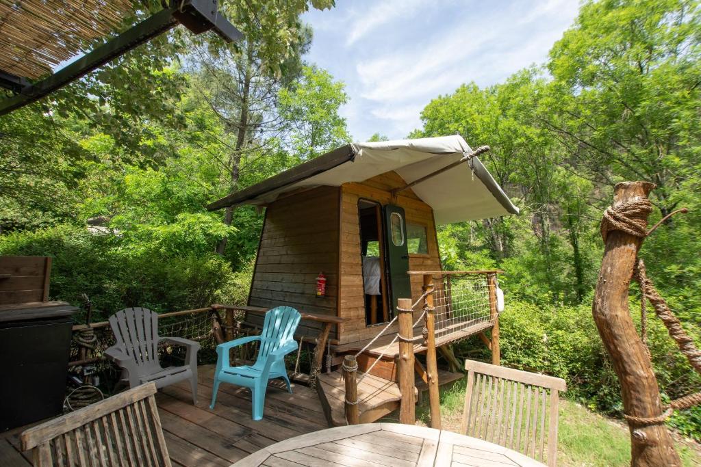 a small cabin with a table and chairs on a deck at la pêcherie in Malbosc