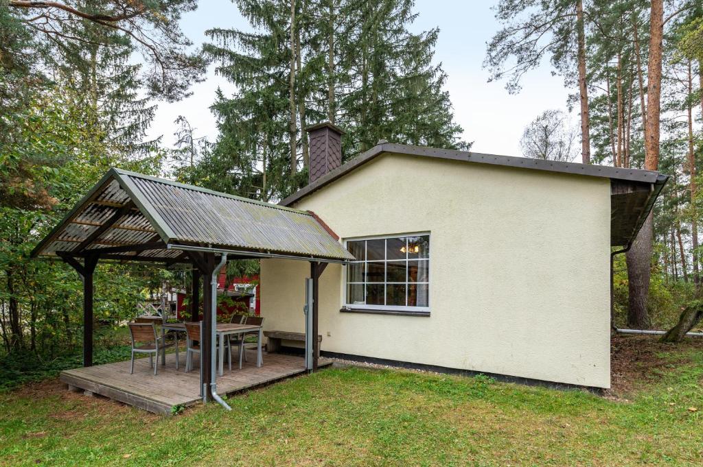 a small white house with a porch and a table at Krüseliner Mühle - Bungalows in Krüselin