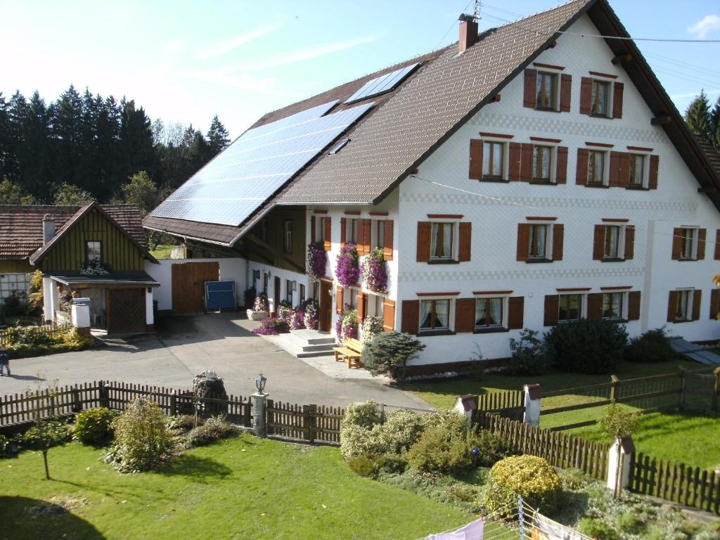 a large white house with solar panels on the roof at Ferienhof Wetzel Fewo 1 in Hergensweiler