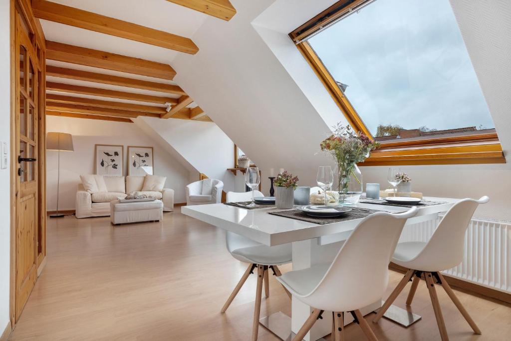 a dining room with a white table and chairs at Hannover Südstadt-Perle in Hannover