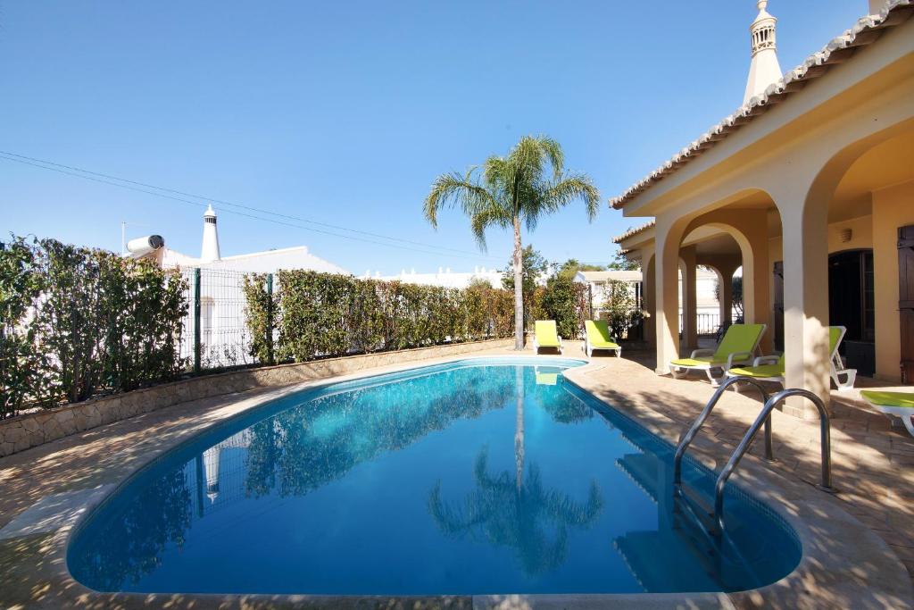 a swimming pool in the backyard of a house at Villa Rústica in Albufeira