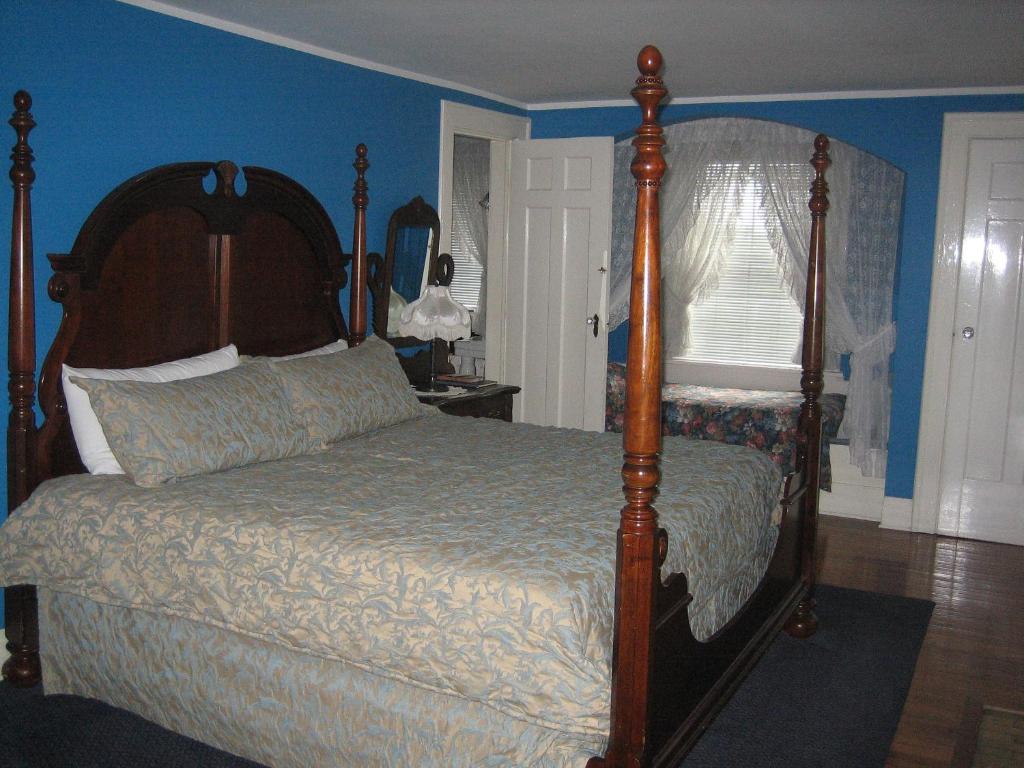 a bedroom with a bed with a wooden frame at Chestnut Inn in Niagara Falls