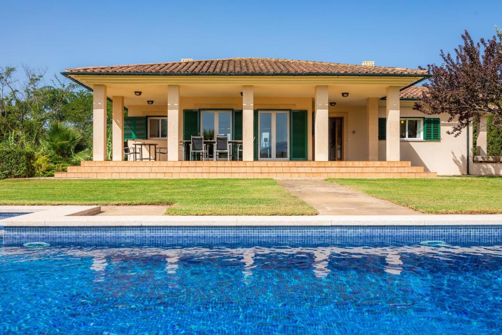 a house with a swimming pool in front of a house at La Vinya del Beato 1950 in Port de Pollensa
