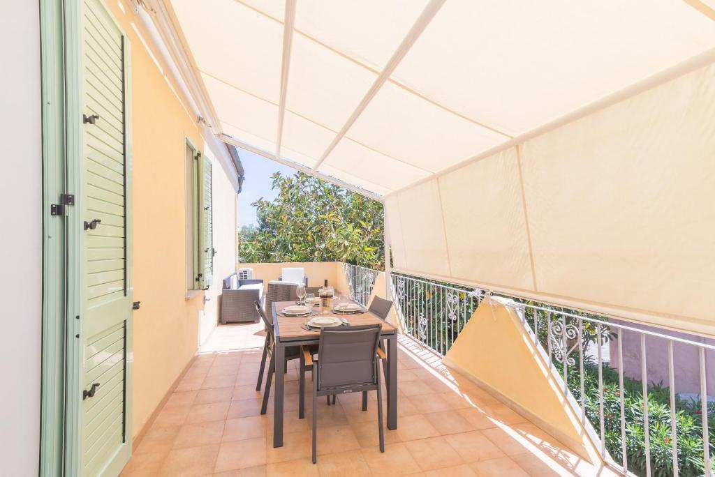 a patio with a table and chairs on a balcony at Maison Chloe 2 in La Maddalena