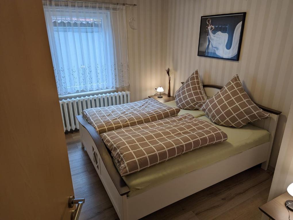 a bedroom with a bed with pillows and a window at Ferienwohung Stelldichein in Altenbrak