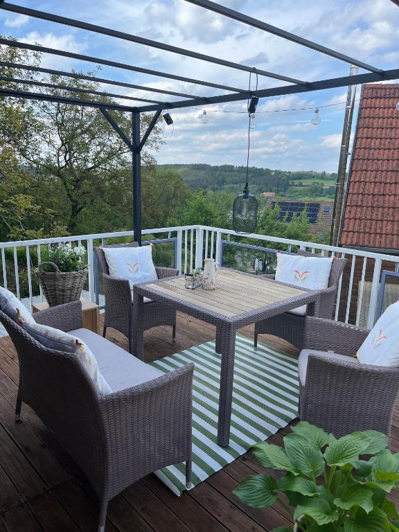 a patio with a table and chairs on a deck at Wohnung mit Dachterasse in Absberg