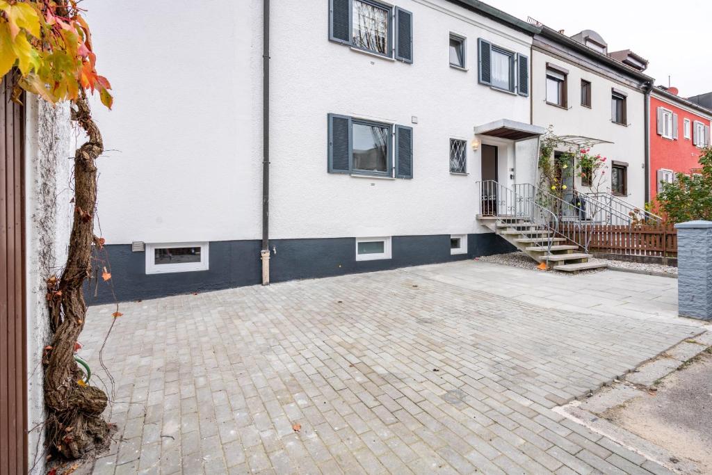 a large white building with a brick driveway at Munich Hideaway in Karlsfeld