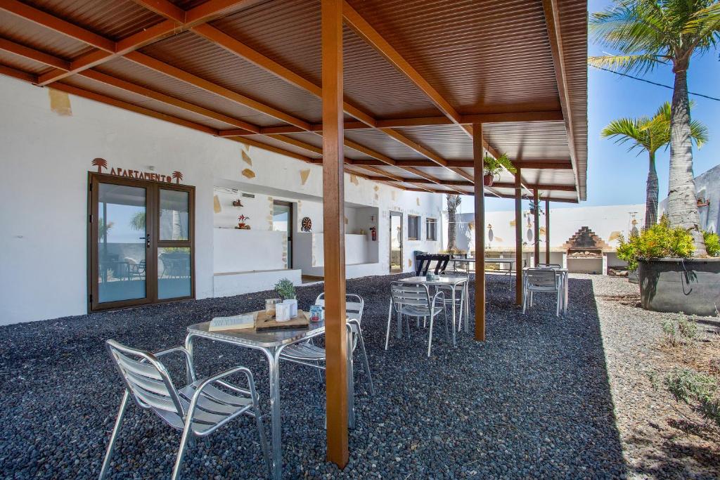a patio with tables and chairs under awning at Las Palmeras in Güimar