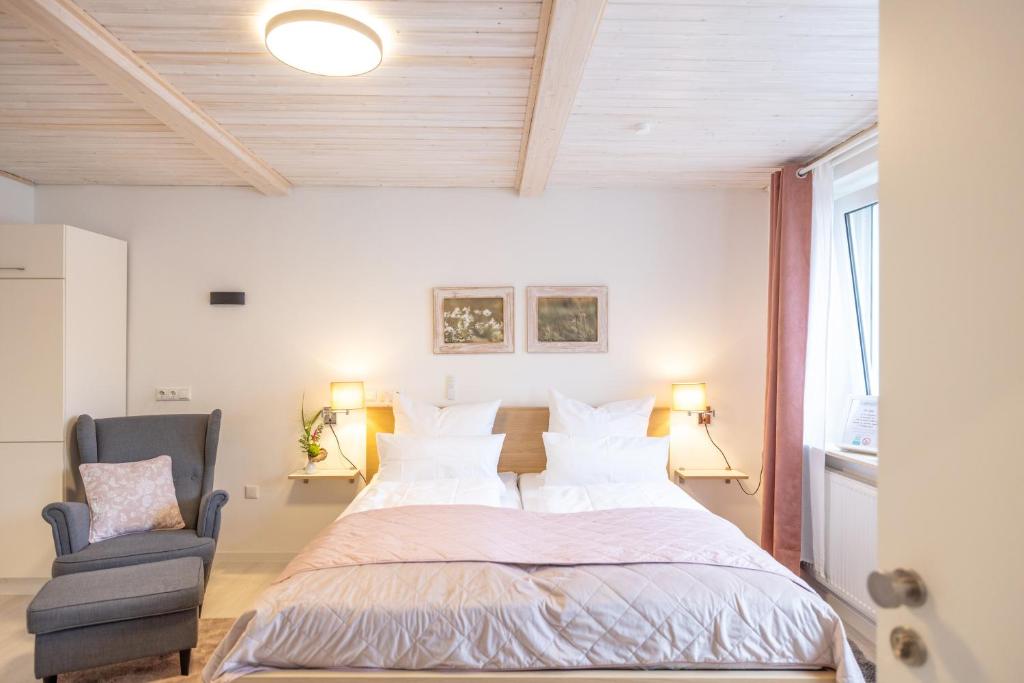 a bedroom with a large bed and a chair at Apartment Wasenberg in Willingshausen