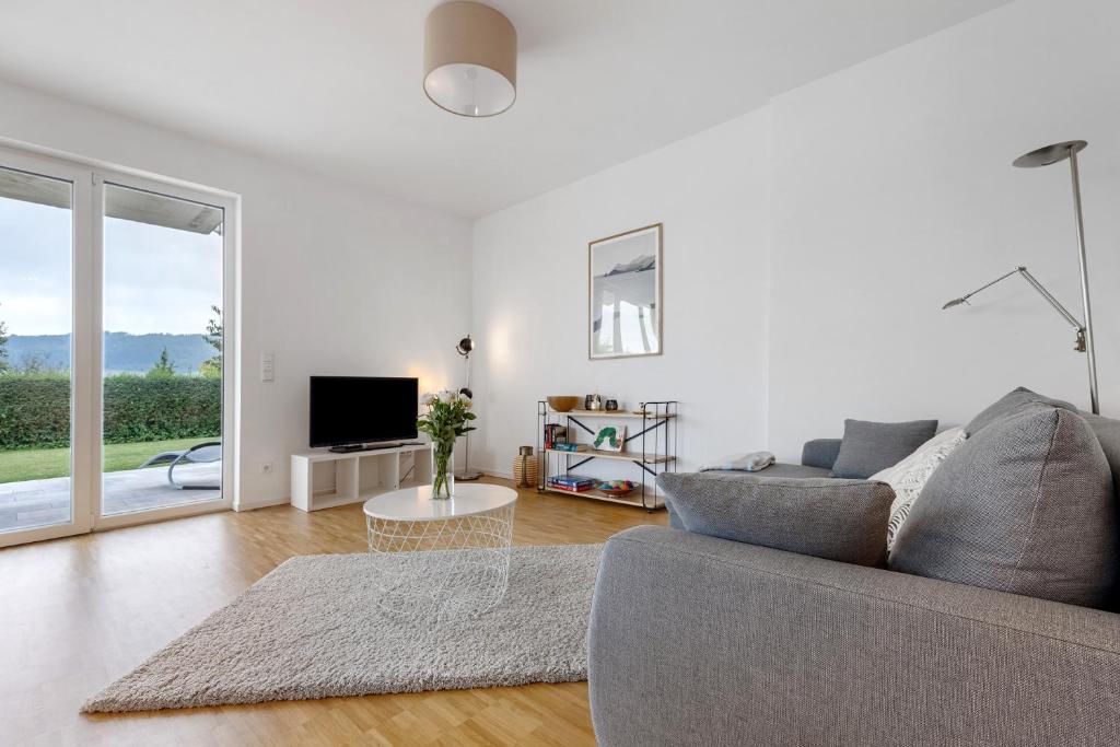 a white living room with a couch and a tv at Auszeit am Wiehengebirge in Bad Essen