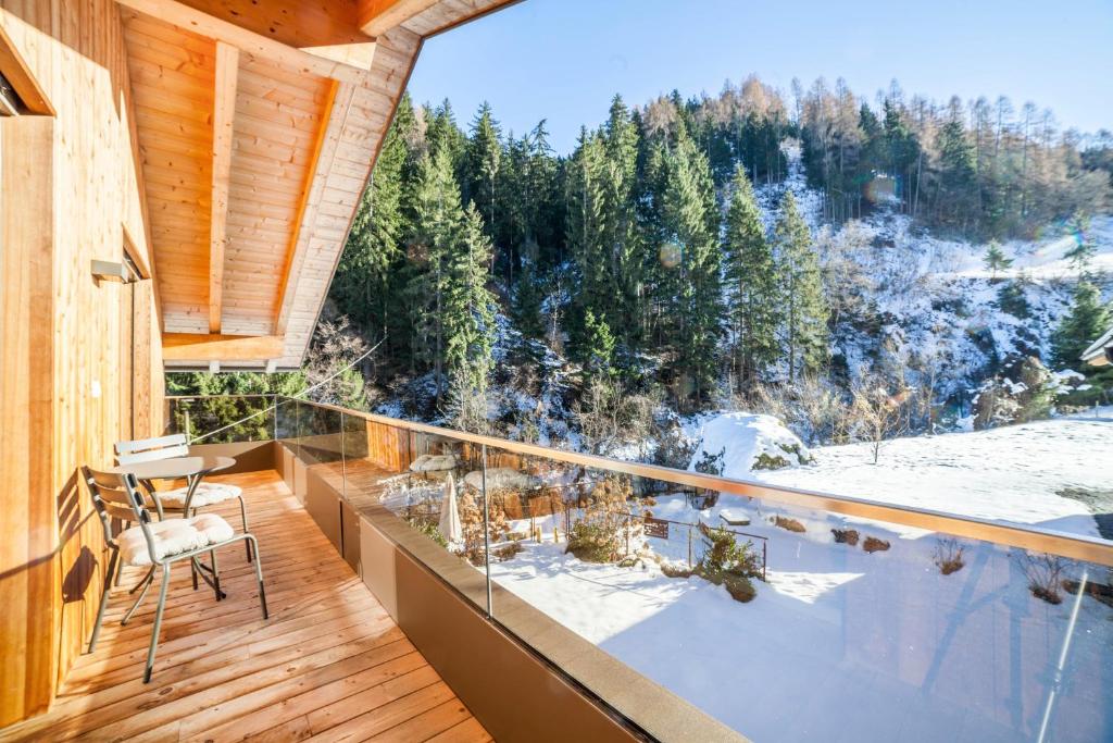 a room with a balcony with a table and chairs at Chalet de Ultimis in Ultimo
