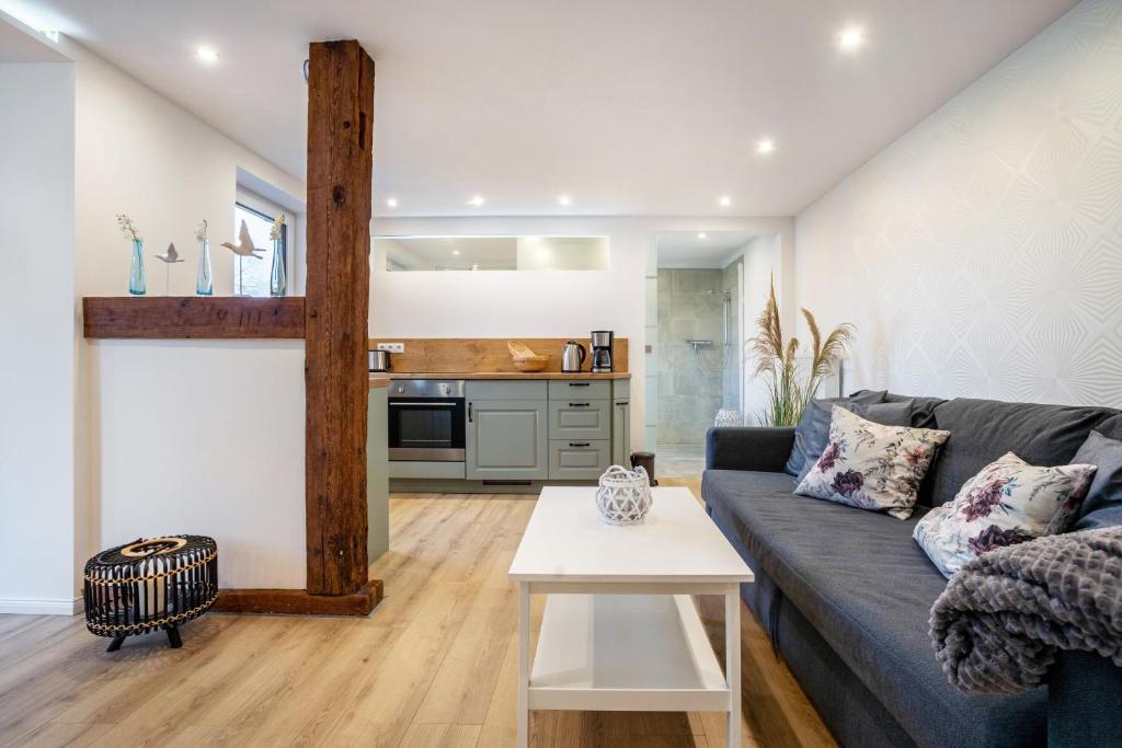 a living room with a blue couch and a kitchen at Ferienwohnung Manthei in Kluis