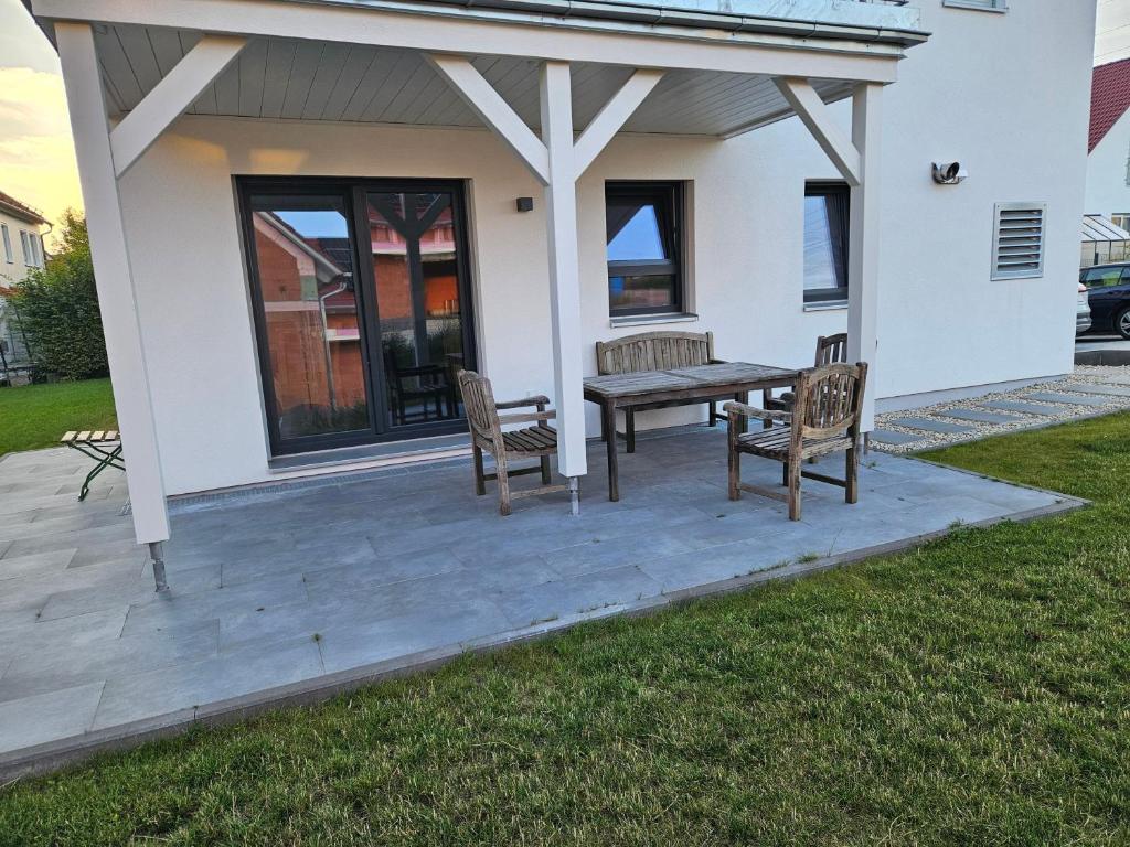 a patio with two chairs and a wooden table at Ferienwohnung Auszeit in Solnhofen