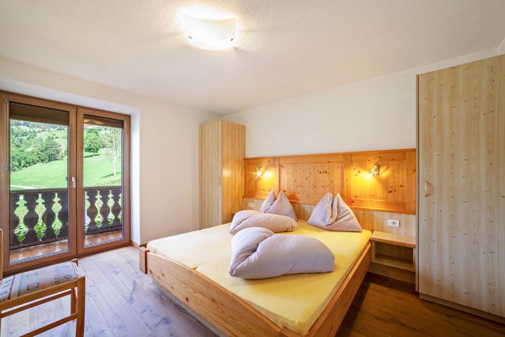 a bedroom with a bed with pillows on it at Fichtenhof Wohnung Enzian in Tarces
