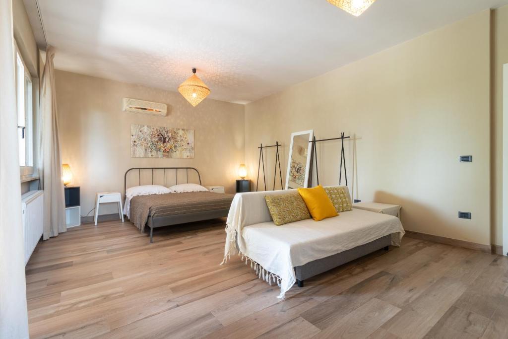 a bedroom with two beds and a couch in it at A Look Salento in Castrignano del Capo