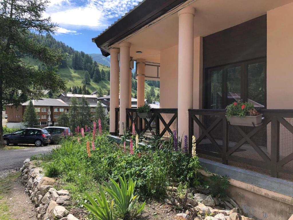 a house with a porch with flowers on it at La Baïta De La Foux in La Foux d'Allos