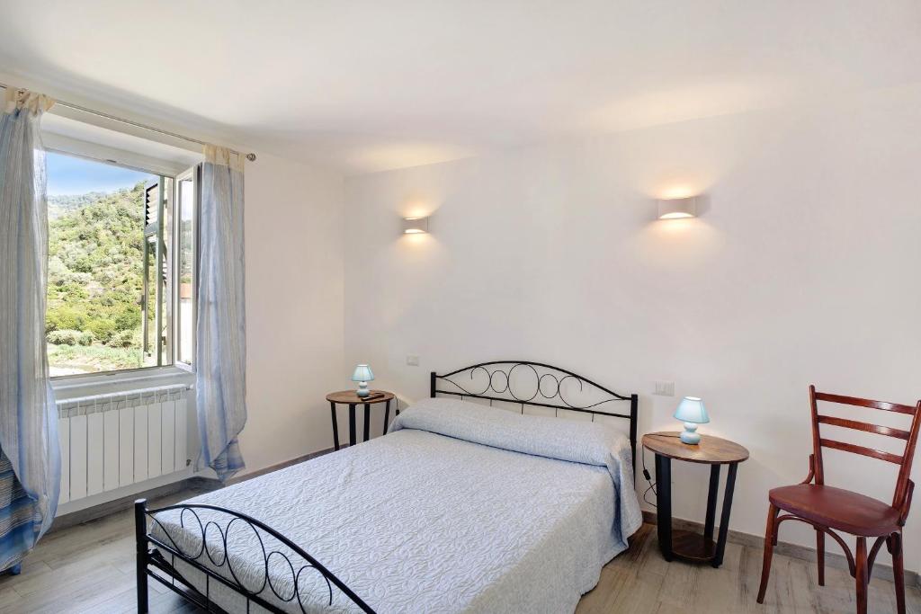 a bedroom with a bed and a large window at G House Dolceacqua in Dolceacqua