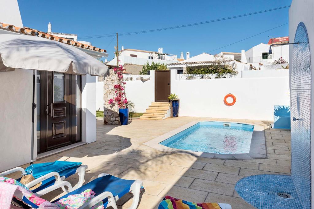 a villa with a swimming pool and a house at Villa Petala in Albufeira