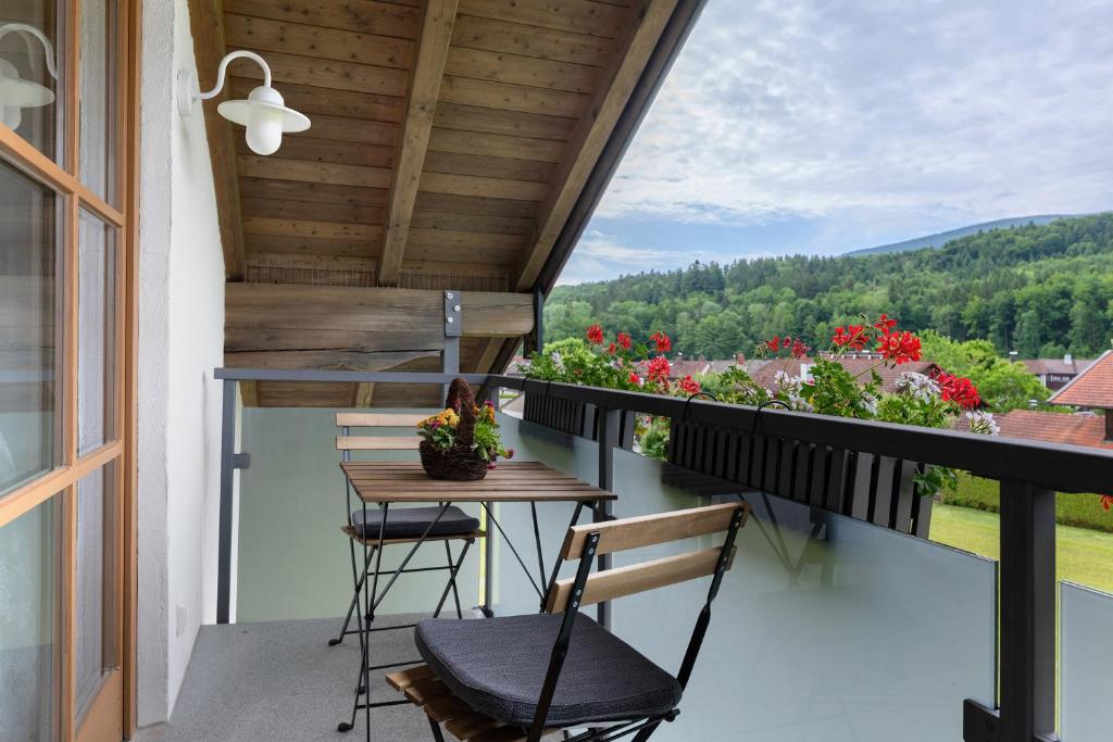 a balcony with a table and chairs and flowers at Ferienwohnung am Teisenberg in Teisendorf