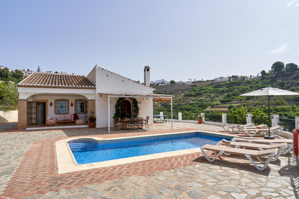 a villa with a swimming pool and a house at Cortijo Los Ángeles Morea in Frigiliana