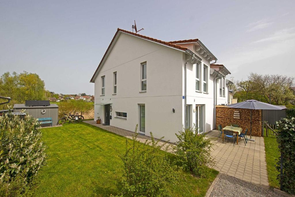 a white house with a patio and a yard at Ferienhaus Moos in Wasserburg