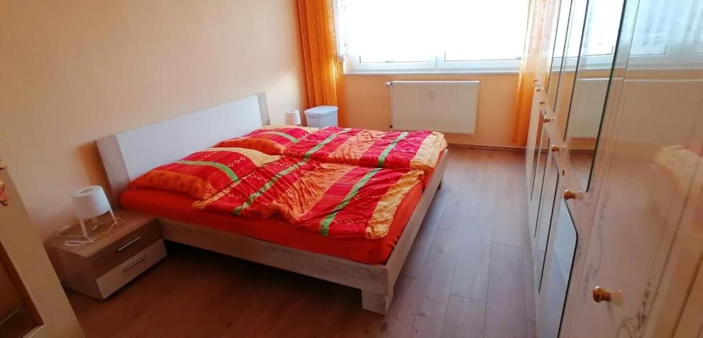 a bedroom with a bed with a red blanket and a window at Ferienwohnung Mücheln 1 in Mücheln