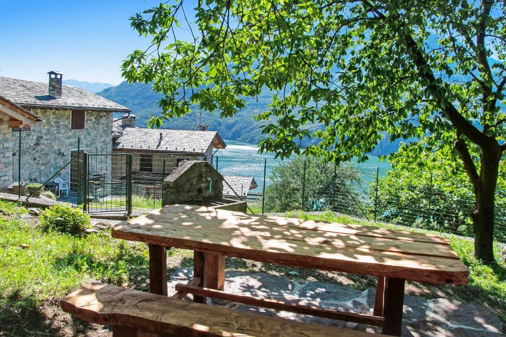 a wooden bench sitting in front of a house at Il ciliegio sul lago in Verceia
