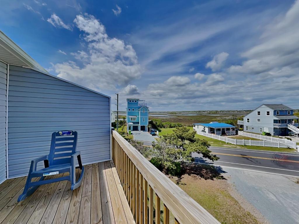 a blue chair sitting on the deck of a house at Lazy Daze in Surf City
