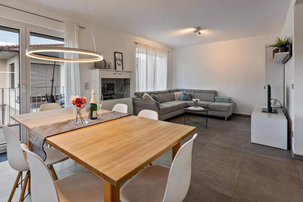 a dining room and living room with a table and chairs at Schmuckstück in Hilzingen