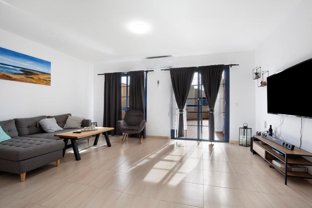 a living room with a couch and a tv at Casa Otoño in Lajita