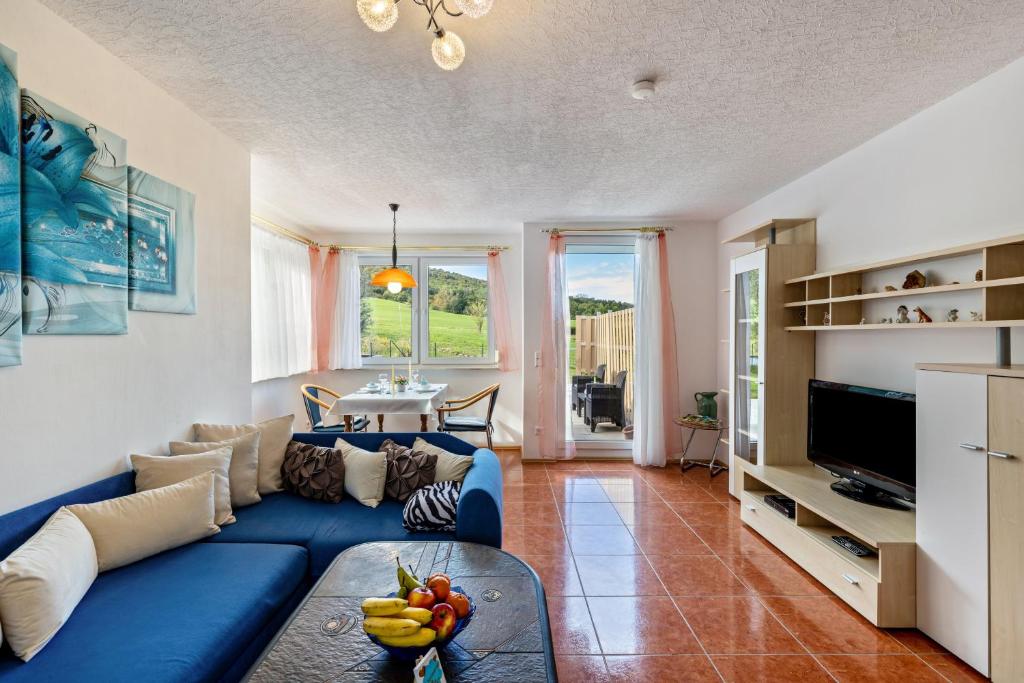 a living room with a blue couch and a table at Apartment Ayleen in Boll