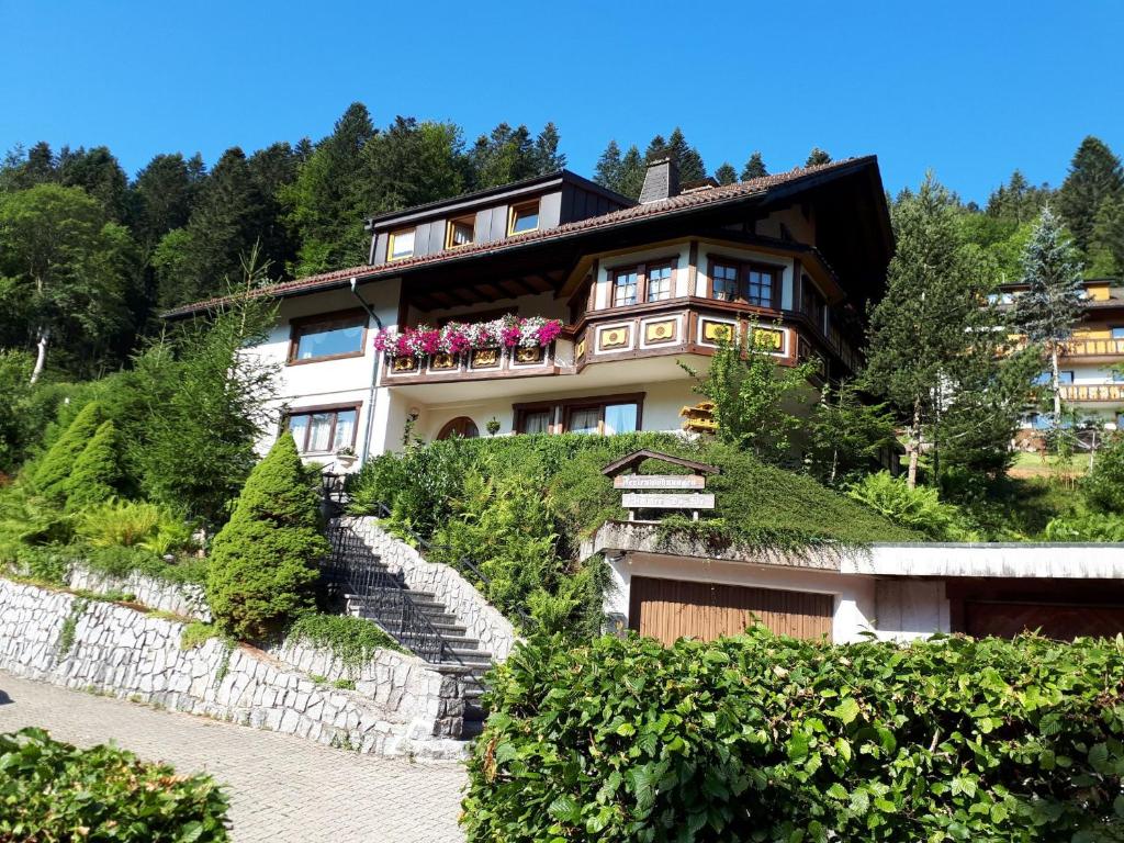 a house on top of a hill with flowers at Haus Kurparkblick in Todtmoos