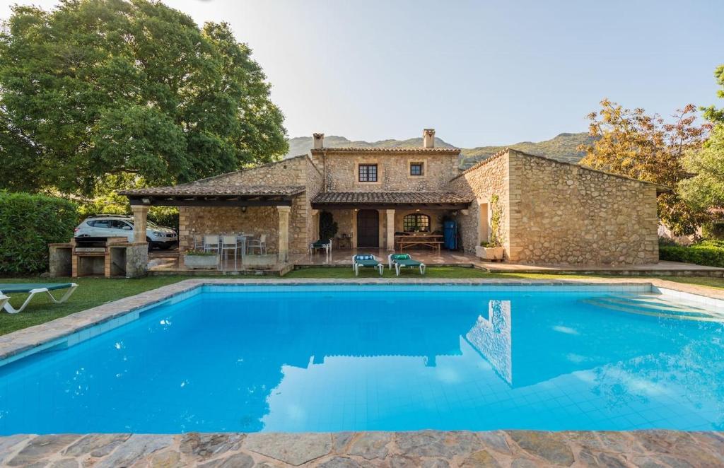 a large pool in front of a stone house at Cuixach villa in Pollensa with Wifi in Pollença
