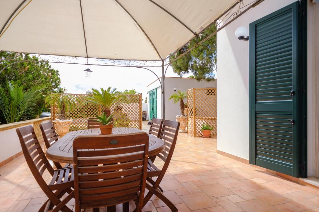 a patio with a table and chairs and an umbrella at Villetta del Salento 1 in Racale
