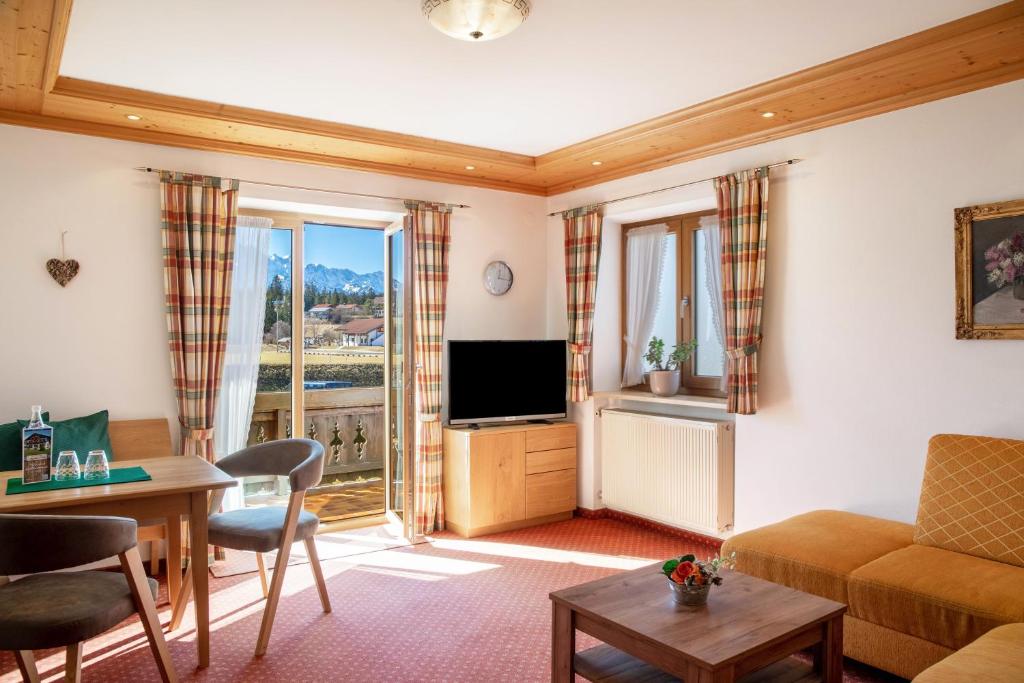 a living room with a couch and a television at Alpenblick Tilly - Fewo Lautersee 3 in Krün