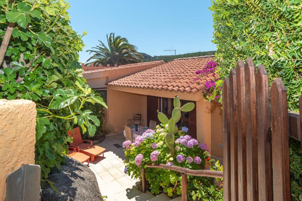 a house with a fence and flowers in the yard at Vecchio Marino H4 in Palau