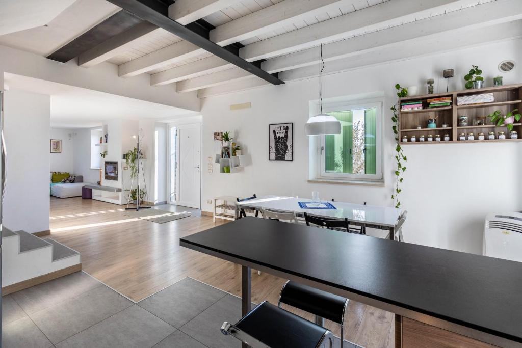 a dining room and living room with a black table at La Casa In Collina Con Vista in Grezzana
