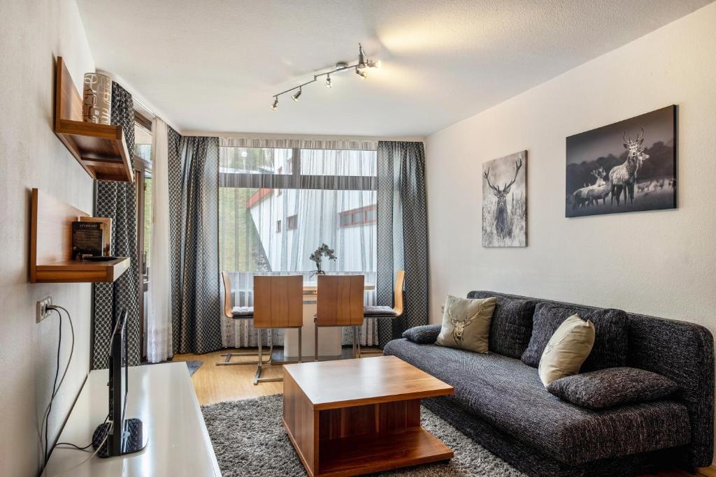 a living room with a couch and a table at 2 Zimmer Appartement mit Pool in Schluchsee