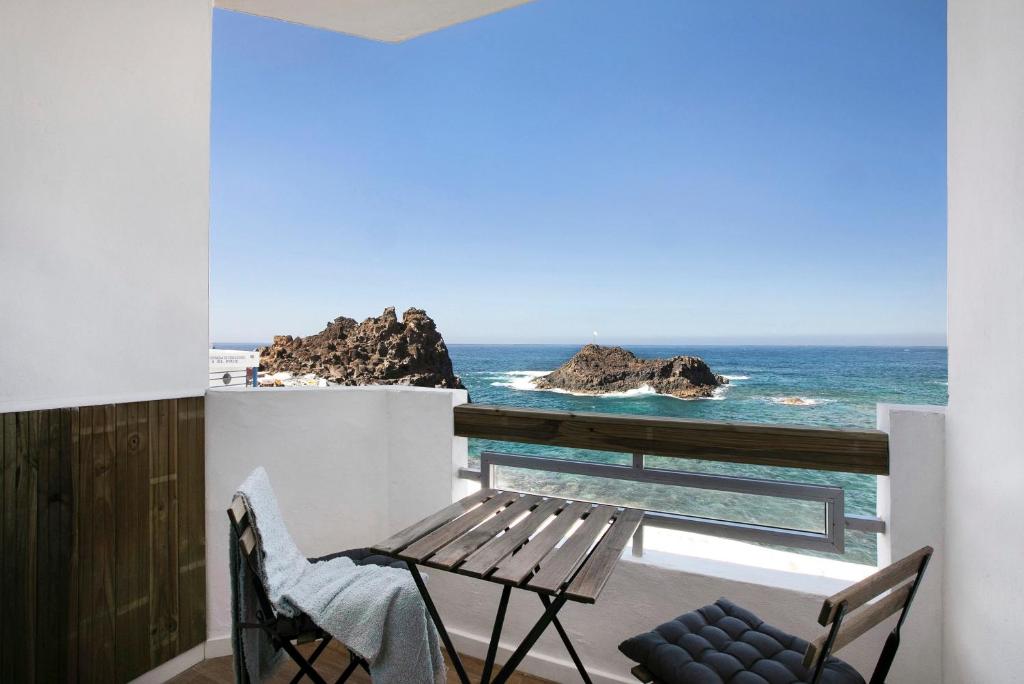 a balcony with a wooden bench and the ocean at Mypris Home 2 in Tacoronte
